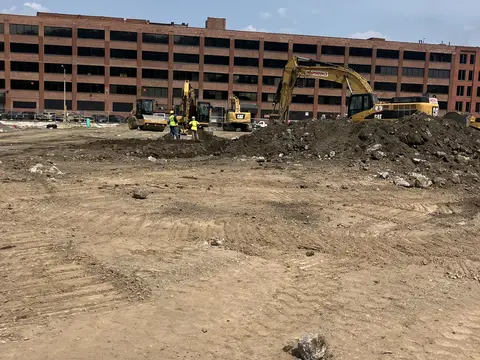 Excavators grading the site, July 2026