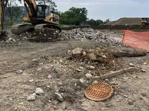 Clearing debris around a former utility. Site work, August 2026