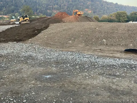 Early morning earthwork below the hillside. Site work, August 2026