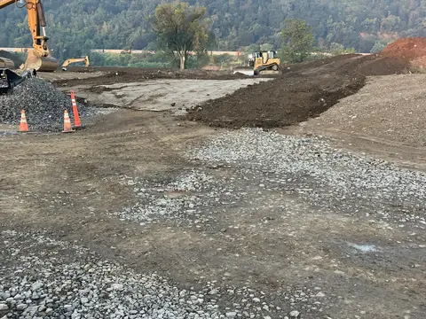 Stone base going down across the site. Site work, August 2026
